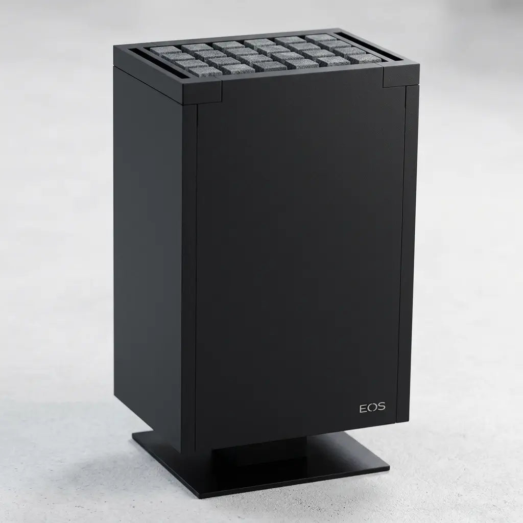 A matte black cubistic electric sauna heater with a grid of cubic sauna stones on top and a small white EOS logo near the bottom right, standing on a matching black base against a light gray background.